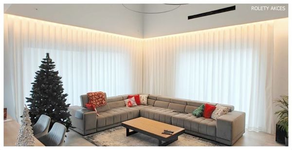 Neutralne, długie zasłony optycznie powiększają salon.